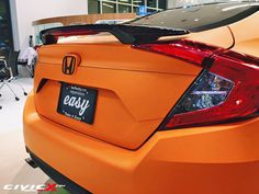 the back end of an orange honda civic