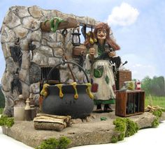 a figurine is standing in front of a stone wall with a pot and other items