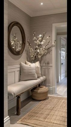 a white bench sitting next to a wall with a mirror on the wall above it