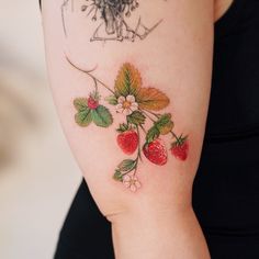 a woman's arm with strawberrys and flowers on it