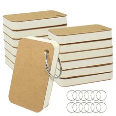 a stack of white and brown luggage tags next to each other with silver rings around them