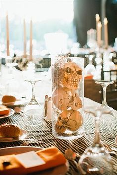 the table is set with wine glasses, cheese and crackers in glass vases