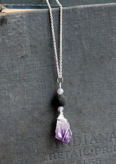 This short necklace has a bead and amethyst pendant hanging from a silver chain. The black bead is a lava rock which can be used to diffuse a drop of essential oil. Pendant Necklace Outfit, Vintage Pendant Necklace, Pendant Necklace Simple, Crystal Necklaces, Lava Rock, Amethyst Pendant, Short Necklace, Diamond Pendant Necklace, Gold Pendant Necklace