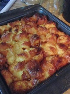 a pan filled with food sitting on top of a wooden table