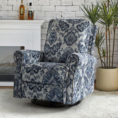 a blue and white chair sitting in front of a fire place next to a potted plant