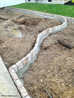 a brick walkway in the middle of a yard that is being built into an area with dirt