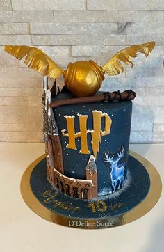 a harry potter birthday cake with gold decorations on top and hogwart's castle in the middle