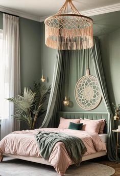 a bedroom with green walls, pink bedding and a chandelier hanging from the ceiling