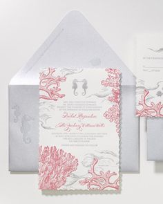 the wedding stationery features coral and silver accents, along with an elegant pocketfold card