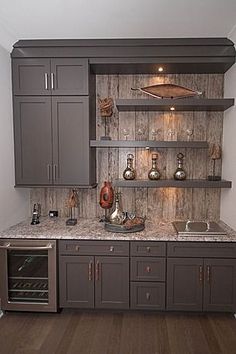 a kitchen with gray cabinets and marble counter tops