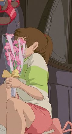 a woman sitting in the back seat of a car holding a bouquet of pink flowers