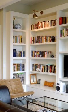 a living room filled with furniture and bookshelves next to a flat screen tv