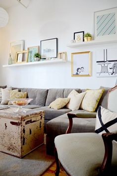 a living room filled with furniture and pictures on the wall