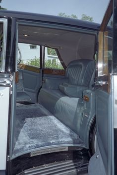 the interior of an old car with its door open and carpeted flooring on