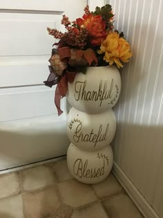 a vase filled with flowers sitting on top of a tile floor next to a door