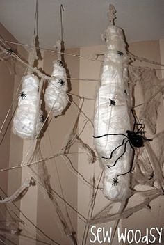 there are several plastic bags hanging from the ceiling with spider webs attached to them