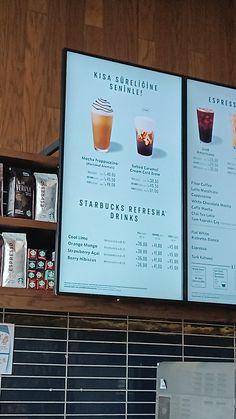 two menus are displayed on the wall above a coffee shop's drink selection