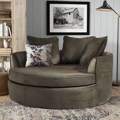 a living room with a round chair and pillows on the floor next to a book shelf