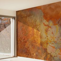 an orange and brown wall in front of a window with a tree outside the window