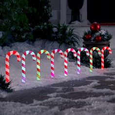 lighted candy canes are displayed in the snow