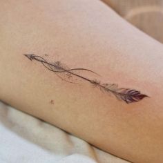 a woman's arm with an arrow tattoo on it