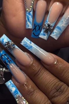 someone is holding up their nails with blue and white designs on them, while they are wearing