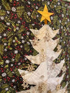 a quilted christmas tree with gold star on top and snowflakes all over it