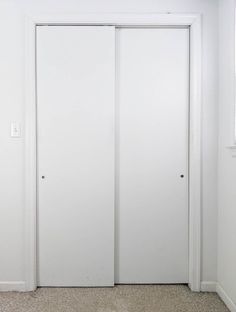 an empty room with two white doors in it