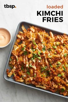 a tray filled with fried kimchi fries next to a cup of coffee and sauce