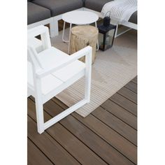 a white table sitting on top of a wooden floor next to a couch and chair