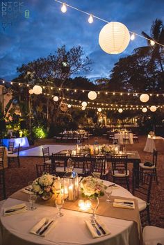 an outdoor dining area with tables and chairs set up for formal function at night time