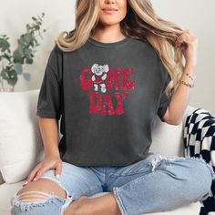 *Also available as a sweater. See below.* Show off your team spirit with the Alabama Game Day T-Shirt. Perfect for football season, this t-shirt is a must-have for any Alabama fan. With its comfortable fit and stylish design, you'll be ready to cheer on your team in style. Don't miss out on this game day essential! Graphic Tee With Slogan For Game Day, Casual Slogan Tops For Fan Gear, Game Day Sports Fan Slogan Tops, Sports Fan Slogan Tops For Game Day, Game Day Graphic Tee With Slogan, Game Day Slogan Graphic Tee, Game Day Fan Apparel T-shirt With Slogan, Game Day Alabama, Alabama Football Shirts Vinyl