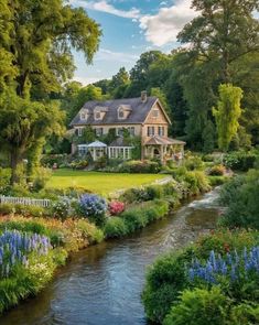 a large house sitting on the side of a lush green field next to a river