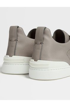 Supple calfskin leather underscores the refined aesthetic of an Italian sneaker featuring triple crisscross elastic straps that offer a custom, flexible fit. Pull-on style with elastic laces Leather upper and lining/synthetic sole Made in Italy Designer Shoes