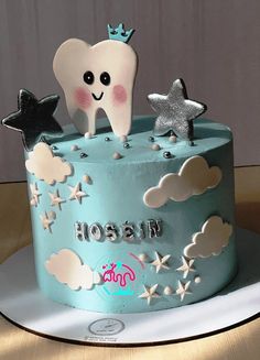 a blue cake decorated with stars and a tooth