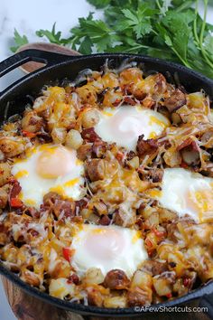 an egg and hash browns in a cast iron skillet with parsley on the side