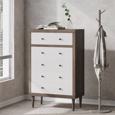 a white and brown chest of drawers next to a window with a coat rack on it