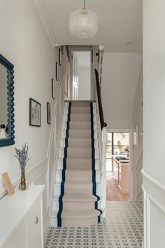 a hallway with blue and white carpeted stairs