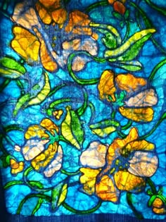 stained glass with yellow flowers and green leaves on blue background, in the shape of a square