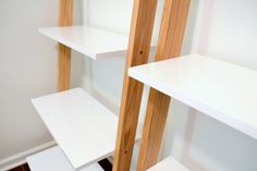 some white shelves in a room with wood trim on the top and bottom shelfs