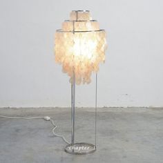 a light that is sitting on top of a metal stand in the middle of a room