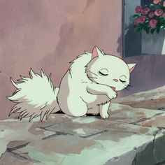 a white cat sitting on top of a stone floor next to a flower planter