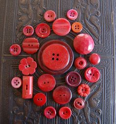 a bunch of red buttons sitting on top of a table