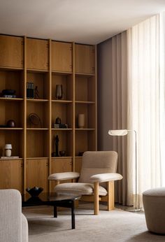 a living room filled with furniture and a book shelf next to a large glass window