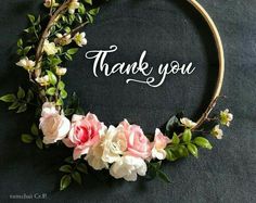 a floral wreath with the words thank you written in white lettering on it and pink flowers