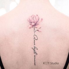 the back of a woman's neck with a pink flower on it