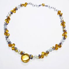 "DESCRIPTION: Thank you for coming in! A breath-takingly beautiful necklace made of an assortment of natural gemstones! You can find Iolite, citrine and aquamarine in this one necklace! Premium quality gemstones finished with gold filled headpins and 18k solid yellow gold clasp! 18\" gorgeous necklace, 145 carats! You'll get the necklace you see! SIZE: 19.2mm center stone. GRADE: Transparent COLOR: Multi" Luxury Topaz Necklace With Gemstone Accents, Faceted Citrine Briolette Necklace, Citrine Gemstone Briolette Necklaces, Citrine Necklace With Natural Stones In Round Shape, Yellow Citrine Briolette Necklace, Citrine Necklace With Natural Stones, Cluster Necklace, Sky Blue Topaz, Beautiful Necklace