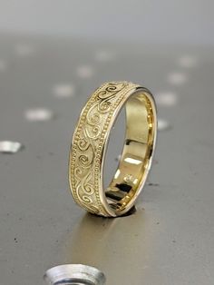 a gold wedding ring sitting on top of a table