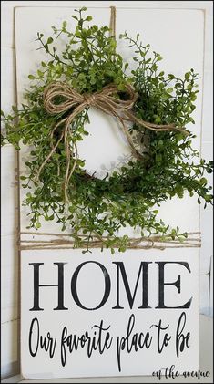 a sign that says home our favorite place to be is hanging on the wall next to a wreath