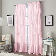 a bedroom with pink curtains and a white rug on the floor in front of a window